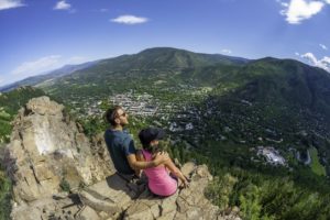 A couple overlooking a ski village in the summer near the Limelight Hotel.