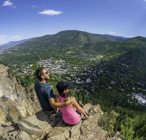 A couple overlooking a ski village in the summer near the Limelight Hotel.