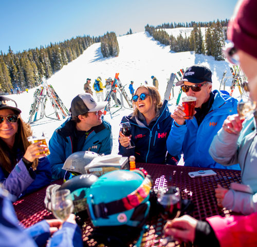 Best On-Mountain Dining Spots - A group of skiers enjoying a drink together